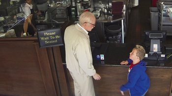 Movie still from “Jackass Presents: Bad Grandpa” (2013), directed by Jeff Tremaine – An older man standing in front of a counter with a young boy; Medium shot, High angle
