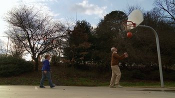 Movie still from “Jackass Presents: Bad Grandpa” (2013), directed by Jeff Tremaine – A man and a boy playing basketball on a basketball court; Wide shot, Low angle