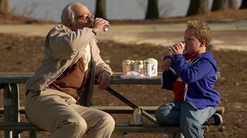 Movie still from “Jackass Presents: Bad Grandpa” (2013), directed by Jeff Tremaine – A man and a boy sitting at a picnic table; Medium shot, High angle