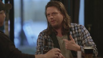 Movie still from “Jackass Presents: Bad Grandpa” (2013), directed by Jeff Tremaine – A man sitting at a table with a beer in front of him; Close Up shot, Over the shoulder angle