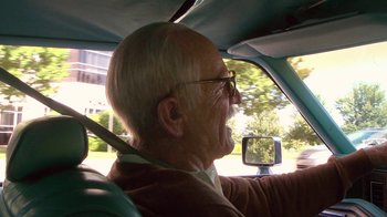 Movie still from “Jackass Presents: Bad Grandpa” (2013), directed by Jeff Tremaine – An older man driving a car with his mouth open; Close Up shot, Low angle