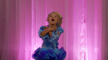Movie still from “Jackass Presents: Bad Grandpa” (2013), directed by Jeff Tremaine – A young girl in a blue and silver dress performing; Medium shot, Low angle