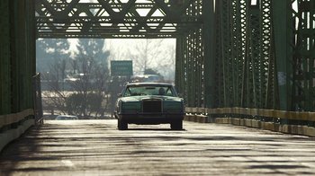 Movie still from “Jackass Presents: Bad Grandpa” (2013), directed by Jeff Tremaine – A car is driving down the street under a bridge; Extreme Wide shot, Low angle