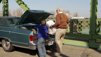 Movie still from “Jackass Presents: Bad Grandpa” (2013), directed by Jeff Tremaine – A man and a boy unloading a car from the back of a car; Wide shot, Over the shoulder angle
