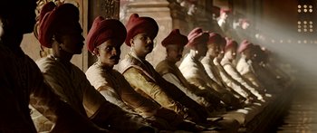 Movie still from “Bajirao Mastani” (2015), directed by Sanjay Leela Bhansali – A group of men sitting next to each other wearing red hats; Medium shot, Low angle