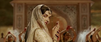 Movie still from “Bajirao Mastani” (2015), directed by Sanjay Leela Bhansali – A beautiful woman in a white dress holding a cell phone; Close Up shot, Over the shoulder angle