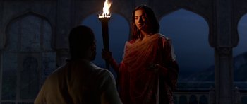 Movie still from “Bajirao Mastani” (2015), directed by Sanjay Leela Bhansali – A woman holding a torch in front of a man; Medium shot, Over the shoulder angle