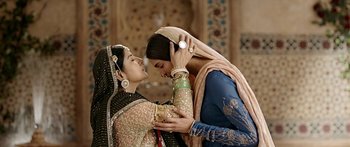Movie still from “Bajirao Mastani” (2015), directed by Sanjay Leela Bhansali – Two women dressed in traditional indian clothing touching each other's hair; Close Up shot, Over the shoulder angle