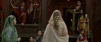 A woman with a veil is standing in front of other women