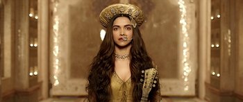 Movie still from “Bajirao Mastani” (2015), directed by Sanjay Leela Bhansali – A woman with long brown hair wearing a hat and holding a guitar; Close Up shot, Low angle