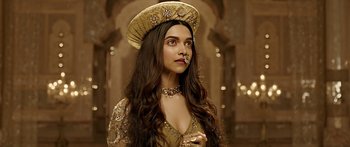 Movie still from “Bajirao Mastani” (2015), directed by Sanjay Leela Bhansali – Deepika padukone in a gold outfit and a hat; Close Up shot, Low angle