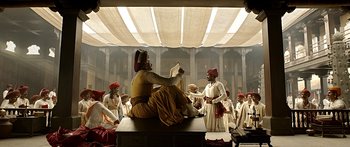 Movie still from “Bajirao Mastani” (2015), directed by Sanjay Leela Bhansali – A group of men standing around a man reading a book; Wide shot, Low angle