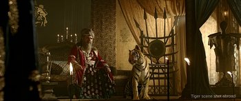 Movie still from “Bajirao Mastani” (2015), directed by Sanjay Leela Bhansali – A man sitting on top of a chair next to a white tiger; Wide shot, Low angle