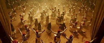 Movie still from “Bajirao Mastani” (2015), directed by Sanjay Leela Bhansali – A group of people in costumes dancing in the sand; Wide shot, Overhead angle