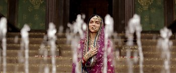 Movie still from “Bajirao Mastani” (2015), directed by Sanjay Leela Bhansali – A woman dressed in a purple and gold sari; Medium shot, Over the shoulder angle