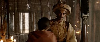 Movie still from “Bajirao Mastani” (2015), directed by Sanjay Leela Bhansali – A man wearing a hat is standing next to another man; Medium shot, Over the shoulder angle