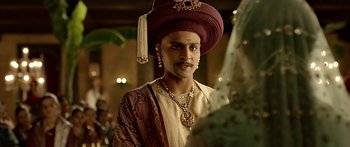 Movie still from “Bajirao Mastani” (2015), directed by Sanjay Leela Bhansali – A man wearing a red turban and a gold necklace; Close Up shot, Over the shoulder angle