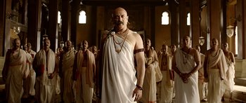 Movie still from “Bajirao Mastani” (2015), directed by Sanjay Leela Bhansali – A man with a beard is standing in front of a group of people; Medium shot, Low angle