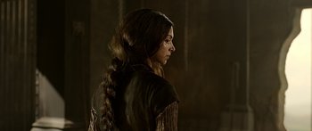 A woman with long brown hair wearing a brown jacket