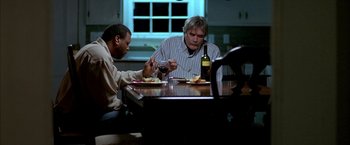 Movie still from “Ballast” (2008), directed by Lance Hammer – Two men sitting at a dinner table with wine; Medium shot, Low angle