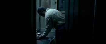 Movie still from “Ballast” (2008), directed by Lance Hammer – A man is washing his hands in a bathroom; Medium shot, High angle