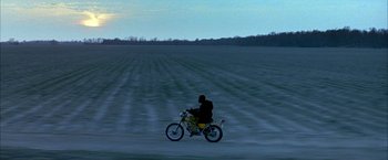 Movie still from “Ballast” (2008), directed by Lance Hammer – A man riding a motorcycle in a field at night; Extreme Wide shot, High angle