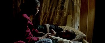 Movie still from “Ballast” (2008), directed by Lance Hammer – Two people sitting on a bed talking to each other; Medium shot, High angle