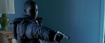 Movie still from “Ballast” (2008), directed by Lance Hammer – A man holding a gun in his right hand; Medium shot, Low angle