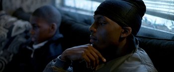 Movie still from “Ballast” (2008), directed by Lance Hammer – A person sitting on a couch with his hand on his chin; Close Up shot, Over the shoulder angle