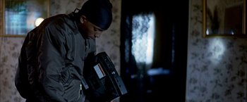 Movie still from “Ballast” (2008), directed by Lance Hammer – A man holding a video tape recorder in his hand; Medium shot, Low angle