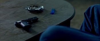 Movie still from “Ballast” (2008), directed by Lance Hammer – A wooden table topped with a knife and a blue object; Extreme Close Up shot, High angle