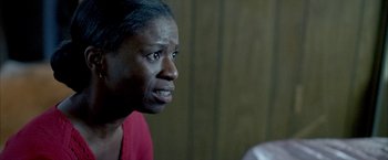Movie still from “Ballast” (2008), directed by Lance Hammer – An older black woman looking angry in front of a wall; Close Up shot, Over the shoulder angle