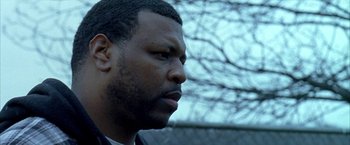 Movie still from “Ballast” (2008), directed by Lance Hammer – A man's face with trees in the background; Close Up shot, Low angle