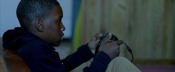 Movie still from “Ballast” (2008), directed by Lance Hammer – A young man holding a cell phone in his hands; Close Up shot, Over the shoulder angle