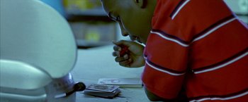 Movie still from “Ballast” (2008), directed by Lance Hammer – A boy is playing a game on a table; Close Up shot, High angle