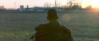 Movie still from “Ballast” (2008), directed by Lance Hammer – A man in a field looking out at the sky; Close Up shot, Over the shoulder angle