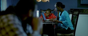 Movie still from “Ballast” (2008), directed by Lance Hammer – Two people sitting at a table looking at a computer; Medium shot, Over the shoulder angle