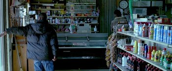 Movie still from “Ballast” (2008), directed by Lance Hammer – Two people are standing in a store looking at the goods on the counter; Medium shot, Over the shoulder angle