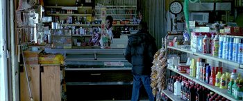 Movie still from “Ballast” (2008), directed by Lance Hammer – A man walking in front of a store counter; Medium shot, Over the shoulder angle