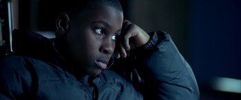 Movie still from “Ballast” (2008), directed by Lance Hammer – A young black man holding a phone to his ear; Close Up shot, High angle