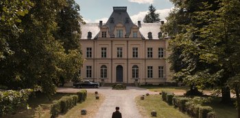 Movie still from “Dark” (2017), created by Baran bo Odar – A man standing in front of a large building; Extreme Wide shot, High angle