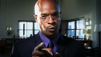 Movie still from “Bamboozled” (2000), directed by Spike Lee – A man in a suit and tie pointing to the camera; Extreme Close Up shot, Low angle