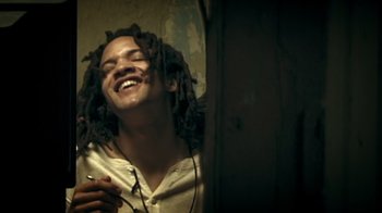 Movie still from “Bamboozled” (2000), directed by Spike Lee – A man with dreadlocks is smiling while listening to music; Close Up shot, Low angle