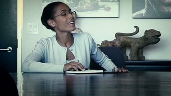 Movie still from “Bamboozled” (2000), directed by Spike Lee – A woman sitting at a table using a laptop computer; Medium shot, Over the shoulder angle