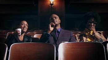 Movie still from “Bamboozled” (2000), directed by Spike Lee – A man and a woman sitting in a movie theater; Medium shot, Low angle