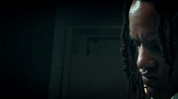 Movie still from “Bamboozled” (2000), directed by Spike Lee – A man with dreadlocks standing in a dark room; Extreme Close Up shot, Low angle