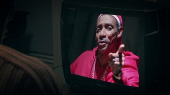 Movie still from “Bamboozled” (2000), directed by Spike Lee – A man wearing a pink shirt and a red robe; Extreme Close Up shot, Over the shoulder angle