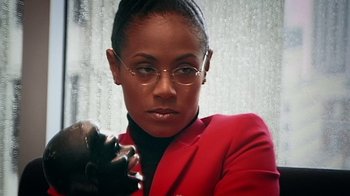 Movie still from “Bamboozled” (2000), directed by Spike Lee – A woman in a red jacket holding a black glove; Close Up shot, Low angle