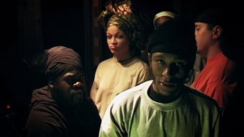 Movie still from “Bamboozled” (2000), directed by Spike Lee – A group of people standing next to each other in a room; Medium shot, High angle