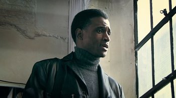 Movie still from “Bamboozled” (2000), directed by Spike Lee – A man wearing a black jacket and a gray sweater; Close Up shot, Low angle